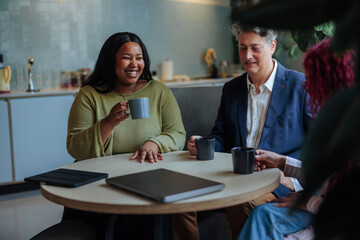 Business people enjoying coffee break in office kitchen