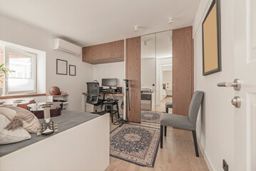 Guest room with a compact wardrobe with folding doors, ideal for small but functional spaces