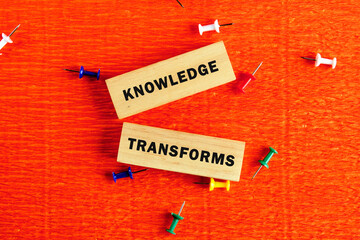 Knowledge learning innovation concept. KNOWLEDGE TRANSFORMS words assembled from wooden blocks in a...