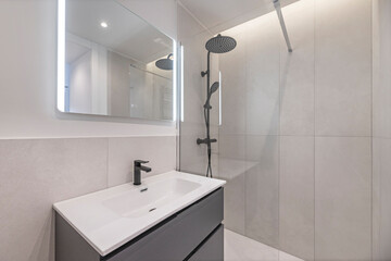 Modern bathroom design with a porcelain sink on a marble countertop, clean-lined chrome faucets, and a corner shower enclosure