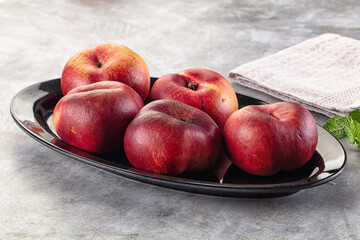 Ripe sweet juicy flat nectarines heap