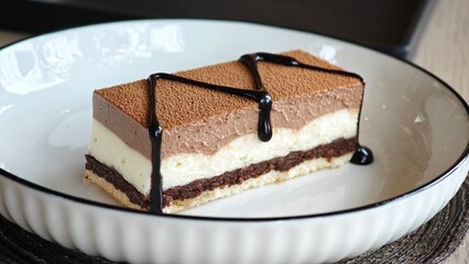 Three chocolates cake with chocolate drips. Layered cake with milk, dark and white chocolate souffle.