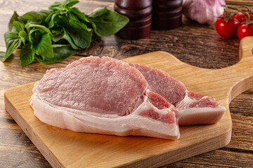 Raw pork steak over board