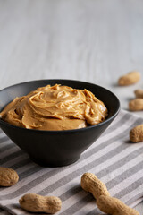 Organic Creamy Peanut Butter in a Bowl, low angle view. Copy space.