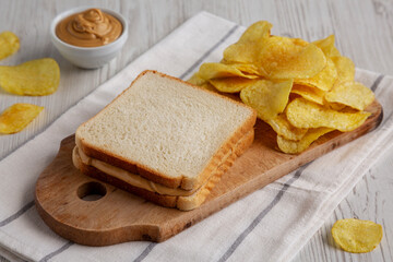 Homemade American Peanut Butter Sandwich and Potato Chips, side view.