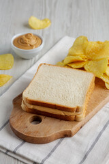 Homemade American Peanut Butter Sandwich and Potato Chips, side view.