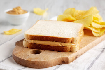 Homemade American Peanut Butter Sandwich and Potato Chips, side view.