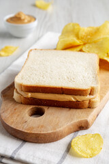 Homemade American Peanut Butter Sandwich and Potato Chips, side view.