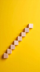 Wooden Blocks Ascending Staircase on Yellow Background Growth Success Concept.