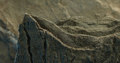 Close-up of rough gray rock with uneven surface and side lighting
