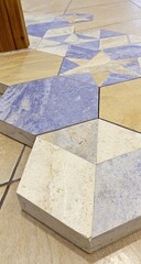 Geometric patterned tiles in cream, beige, and blue, arranged in a hexagonal mosaic design