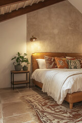 Cozy bedroom interior with warm lighting, earthy tones, decorative pillows, plants and textured rug creating a rustic and inviting atmosphere.