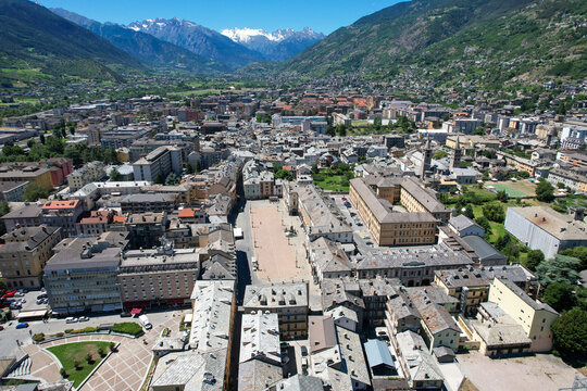 Aerial view of the ancient Porta Pretoria standing bold against the city's skyline, nestled amidst the verdant valley and distant snow-capped mountains, Aosta, Valle d'Aosta, Italy.