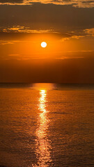 A calm sea at sunrise, gentle waves reflecting golden light