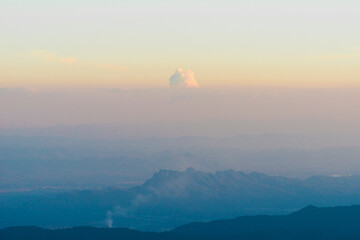 Tranquil Mountain Layers with Isolated Cloud Under Warm Sunset Sky