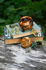 witch copper cauldron, crystal minerals, symbolic moon amulet, vintage keys, spell books in forest. Magic Ritual. spiritual esoteric practice. witchcraft