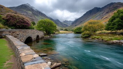 Obraz premium Ancient Stone Bridge Over Misty Mountain River