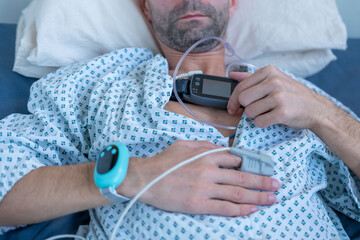 Young person, man with sleep apnea monitoring device and fingertip pulse oximeter, male patient...