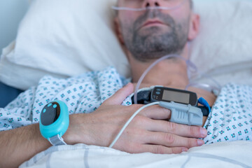 Young person, man with sleep apnea monitoring device and fingertip pulse oximeter, male patient...