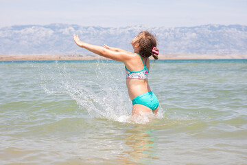 Girl playing in the water at the beach