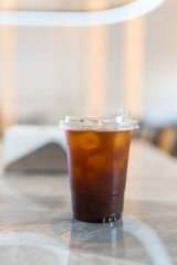 Glass of iced black coffee on a marble table