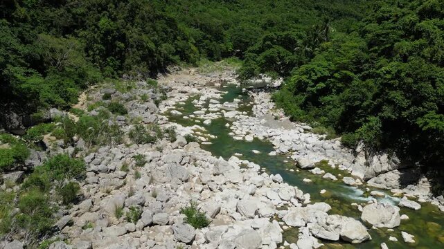 The shot pulls away, expanding the view to reveal the full landscape and plants lining the edges near Tinipak River in Tanay, Philippines.