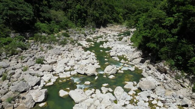Slow forward movement with a slight rotation shows the river&rsquo;s length and surrounding plants, capturing the expansive nature of Tinipak River, Philippines.
