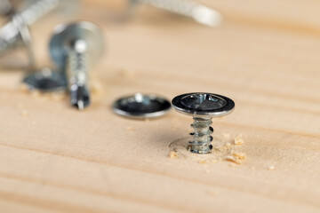 silver screws for wood on the board, wooden board made of pine or other coniferous species and...