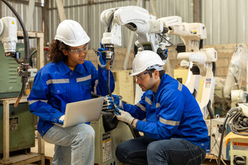 Electrical engineer testing artificial intelligence robot arm at high technology research...