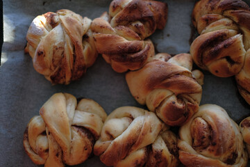 Freshly baked cinnamon buns on a baking sheet with paper