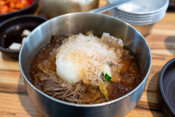 Korean Naengmyeon Cold Noodles with Egg and Vegetables in Chilled Broth.