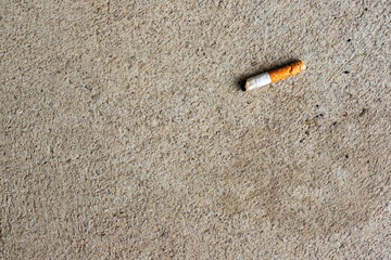 Cigarette butt on the ground. Selective focus on cigarette