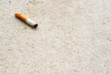 Cigarette butt on the ground. Selective focus on cigarette © ckDome