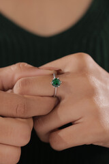 Elegant silver ring with a round green gemstone showcased on a woman's finger, symbolizing style and sophistication.