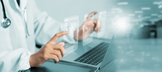 Futuristic EMR interface concept showing doctor interacting with transparent digital patient records using laptop, displaying medical data in modern clinical environment with blue lighting.