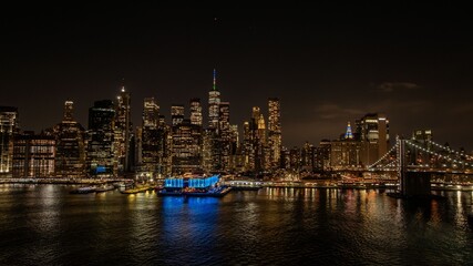 Fototapeta premium New York City skyline at night with Brooklyn Bridge.