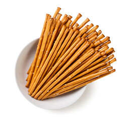 Salty cracker sticks in a plate on a white background. Top view