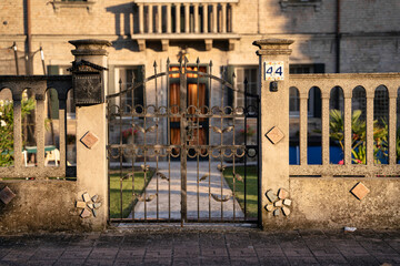 Wrought iron gate protecting private property with number and mailbox