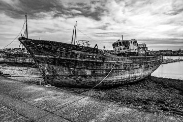 Ces clichés en noir et blanc mettent en valeur des vieux bateaux de pêche abandonnés dans le...