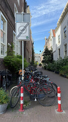 Amsterdam, Netherlands. Bicycles parked along a narrow street in Amsterdam, showcasing charming...