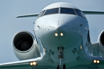 Obraz premium Close-Up of Passenger Jet Nose and Cockpit Windows. Airplane in the blue sky, close-up of the plane