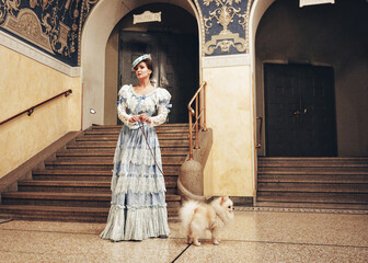 Elegant woman standing with Pomeranian dog near arched entrance