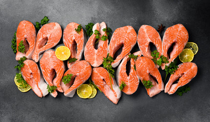Salmon steaks. Set of raw salmon steaks on gray textured background. Top view. Wide banner.