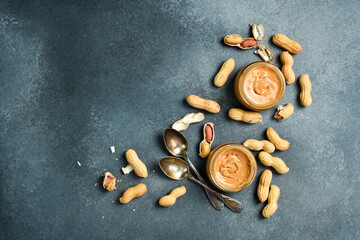 Delicious peanut butter in a glass jar. Homemade nut paste. Nuts close-up.
