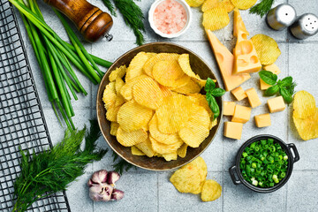 Cheese flavored potato chips in a ceramic bowl. Salty snacks.