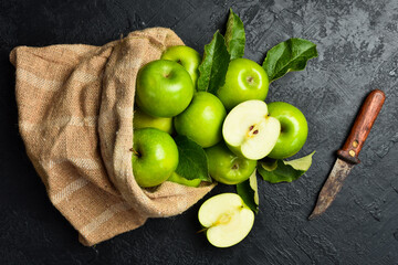 Ripe green apples in a linen bag. Close-up. On a stone background. Top view.