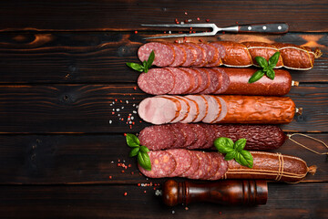 Set of different types of salami and smoked sausage with spices. Sliced salami slices. Top view. On...
