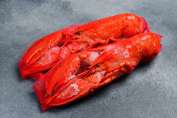 Frozen lobster in ice glaze. Seafood delivery. On gray concrete background, top view.