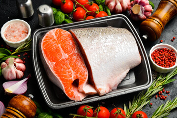 Fresh fish. Juicy piece of raw salmon or trout fish. Fish on a plastic black container from the...