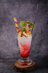 Strawberry-lime red cocktail with ice and a fresh mint garnish in a glass